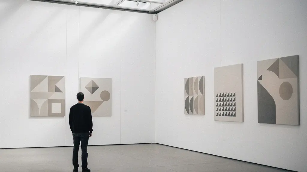 Curator standing in contemporary gallery space arranging conceptual artwork displays with dramatic lighting