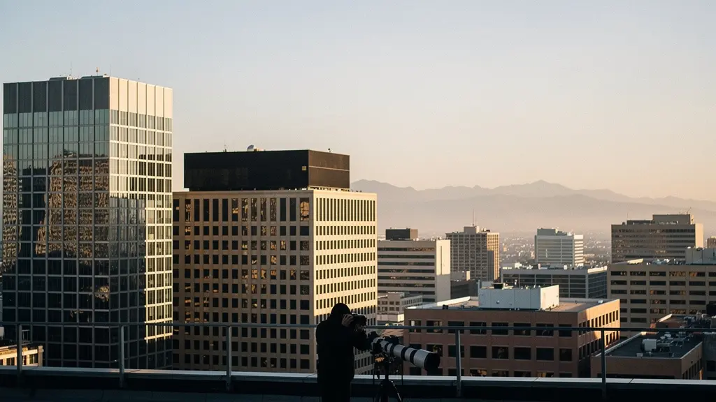 Photographer capturing compressed urban layers with telephoto lens showing distant buildings stacked behind foreground architecture