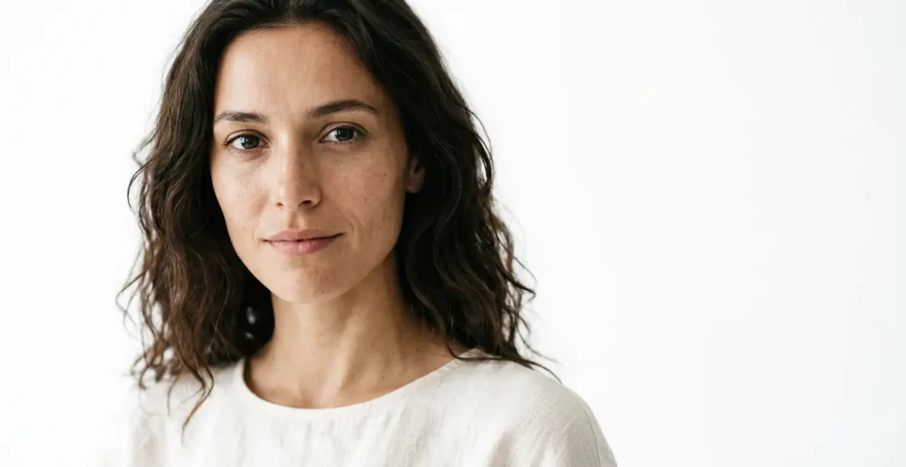 Professional high-key portrait showcasing ethereal lighting and pure white background with subtle form definition