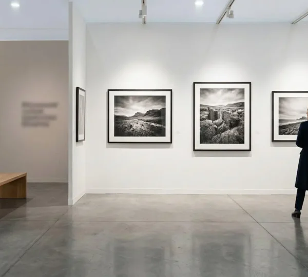 Contemporary art fair booth interior showcasing fine art photography prints with professional lighting and elegant display